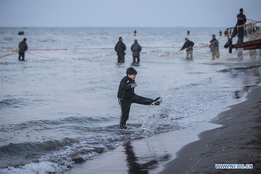 A boy plays with water as Iranian fishermen work at the Caspian sea beach near Anzali Port, northern Iran, on March 27, 2017. (Xinhua/Ahmad Halabisaz) A boy plays with water as Iranian fishermen work at the Caspian sea beach near Anzali Port, northern Iran, on March 27, 2017. (Xinhua/Ahmad Halabisaz)
